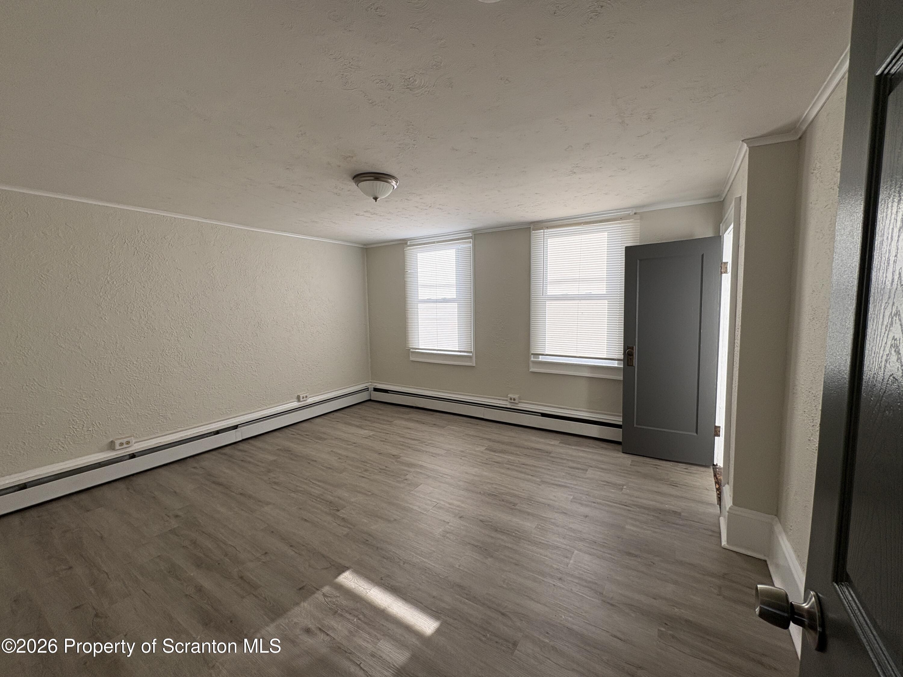 513 Oak Street Old Forge, PA 18518 - Photo 8 of 14 an empty room with wooden floor and windows