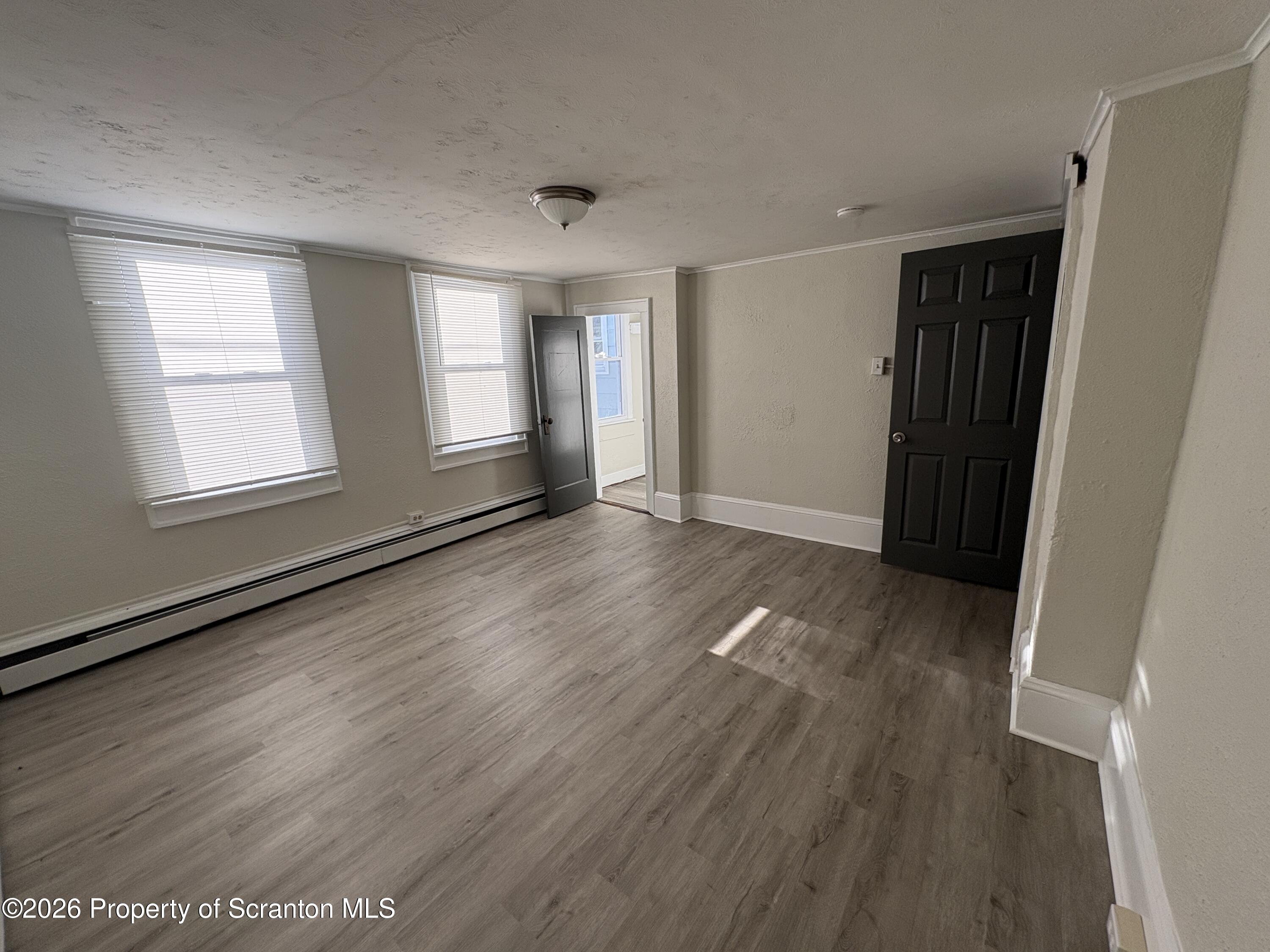 513 Oak Street Old Forge, PA 18518 - Photo 9 of 14 an empty room with wooden floor and windows