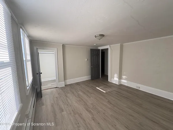 an empty room with wooden floor and a window