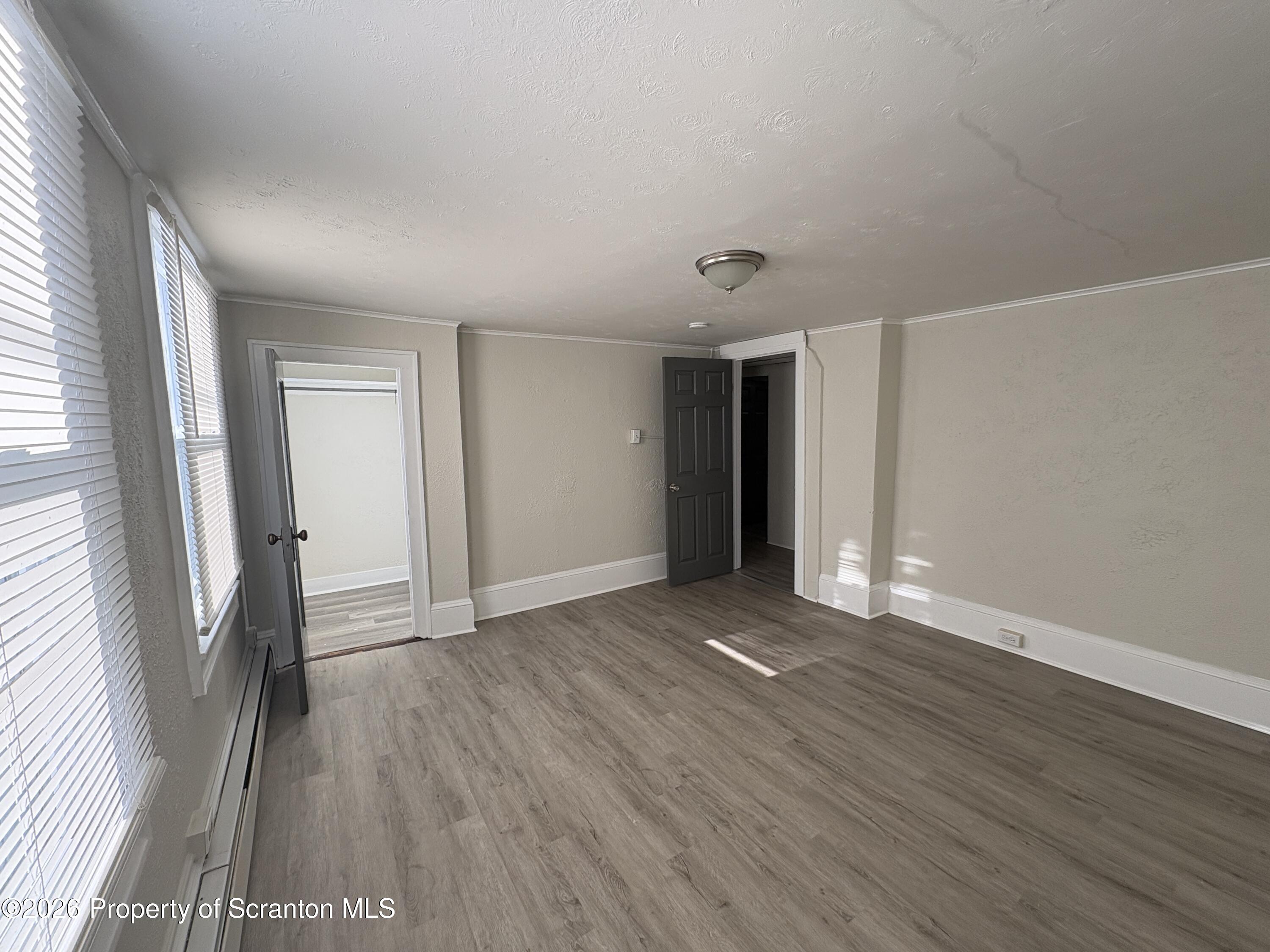 513 Oak Street Old Forge, PA 18518 - Photo 10 of 14 an empty room with wooden floor and a window