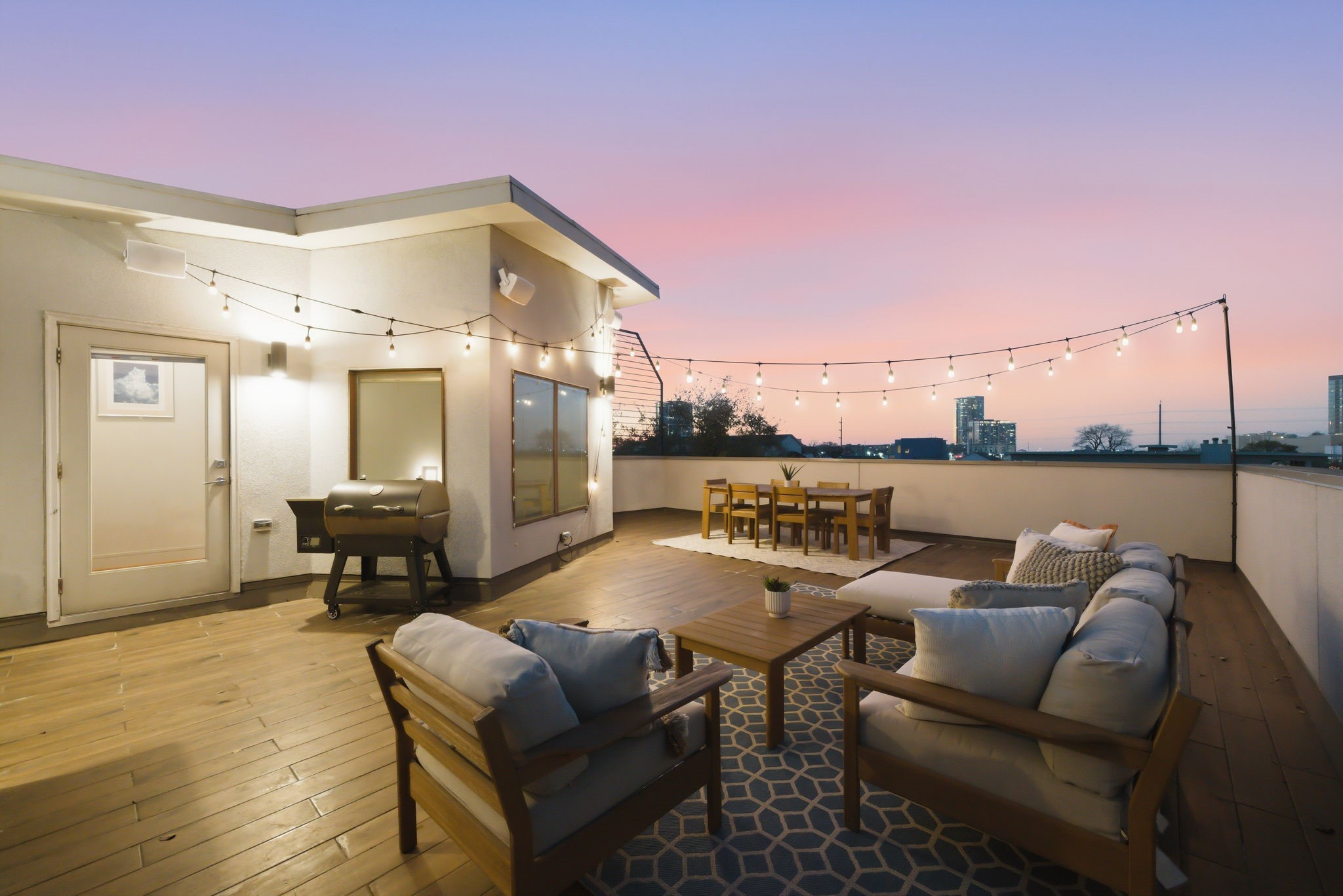 1405 Vermont Street, Unit A Houston, TX 77006 - Photo 7 of 46 Expansive rooftop deck offers a sophisticated retreat with a full seating area and dedicated dining zone under a canopy of string lights. Low-maintenance flooring and a high-end summer kitchen with a gas grill make this the ultimate setting for hosting guests against the backdrop of the city skyline.