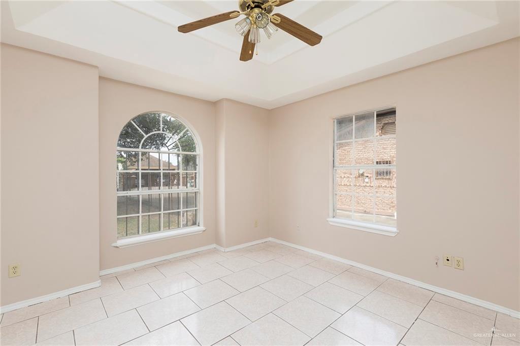 508 Patricia Street Mission, TX 78572 - Photo 6 of 24 Room featuring a tray ceiling with a ceiling fan, light-toned walls, and large format tile flooring