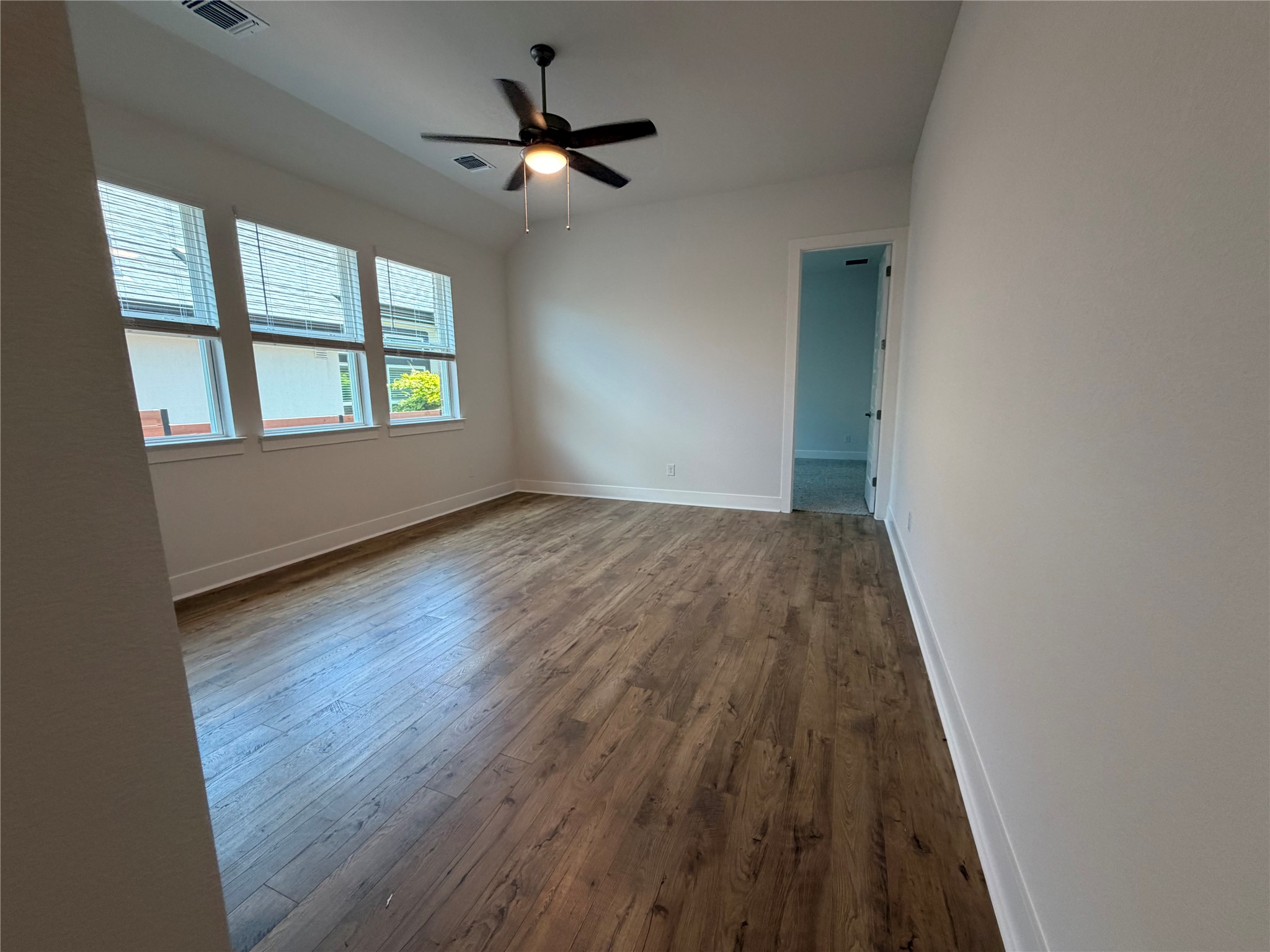 2212 Tobiano Trace Georgetown, TX 78633 - Photo 5 of 33 Well-lit room featuring rich hardwood flooring and a stylish ceiling fan for comfort.