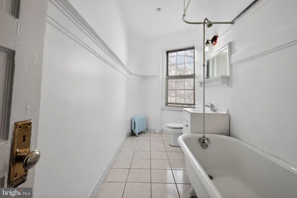 a bathroom with a tub a sink and mirror