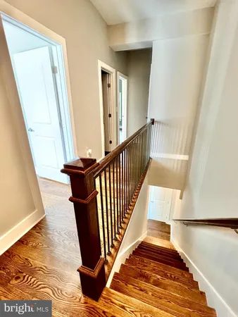 a view of a hallway with wooden floor and staircase