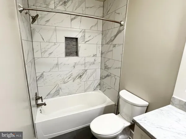 a white toilet sitting next to a bath tub and shower