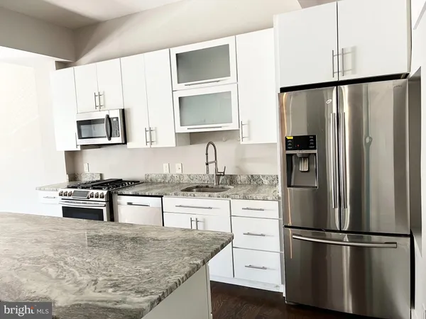 a kitchen with stainless steel appliances granite countertop a refrigerator stove microwave and sink