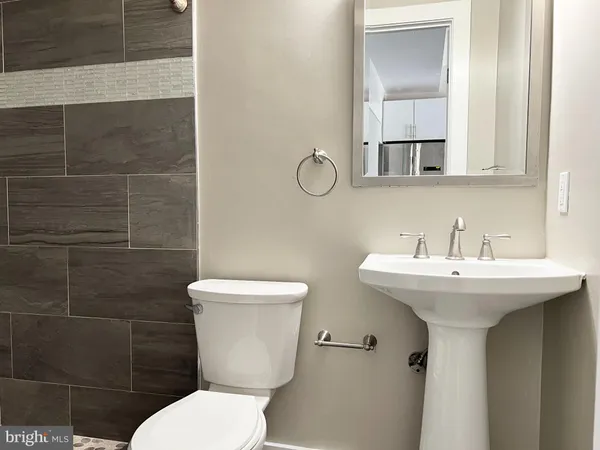 a bathroom with a toilet sink and mirror