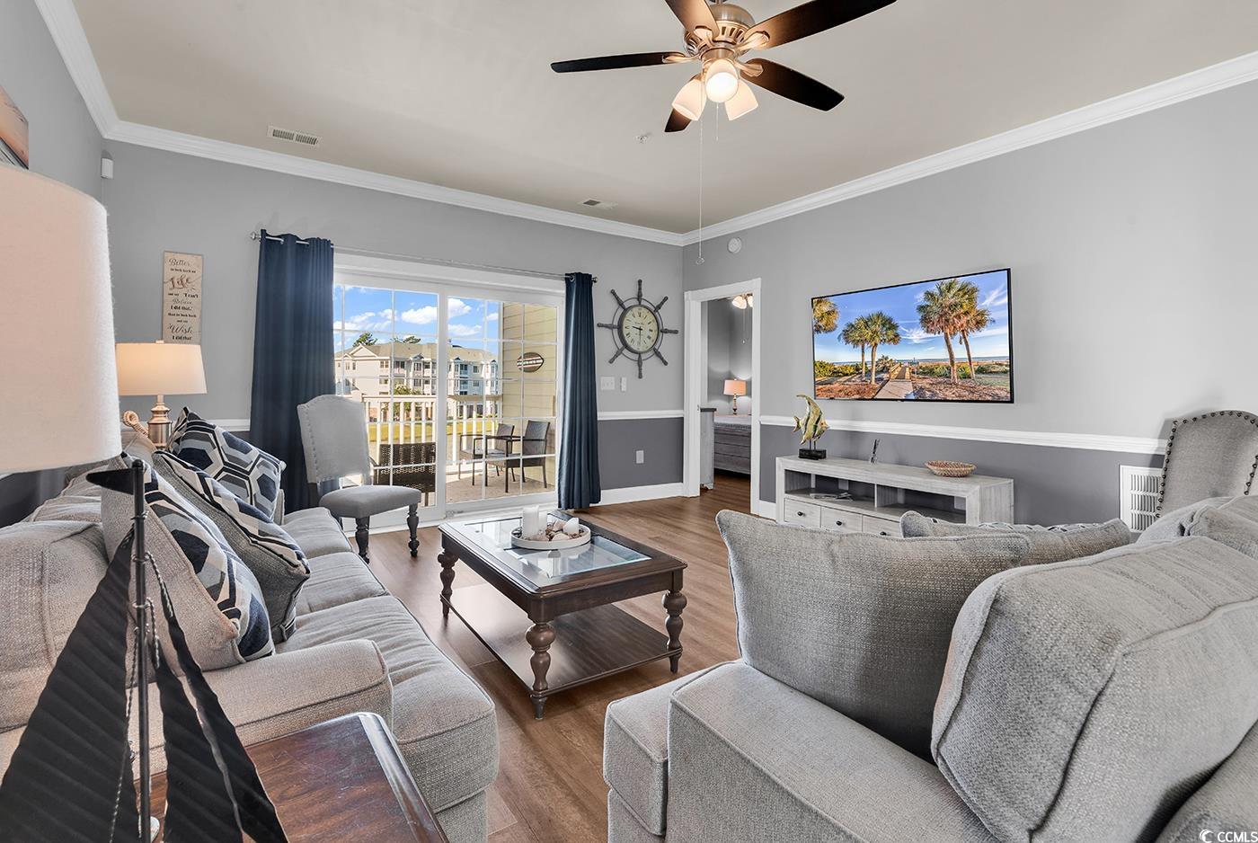 4829 Luster Leaf Circle, Unit 301 Myrtle Beach, SC 29577 - Photo 12 of 34 Living area featuring ornamental molding, wood finished floors, and ceiling fan