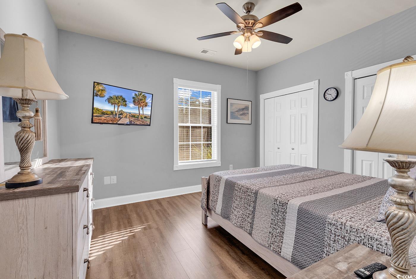 4829 Luster Leaf Circle, Unit 301 Myrtle Beach, SC 29577 - Photo 16 of 34 Bedroom with a closet, wood finished floors, and a ceiling fan