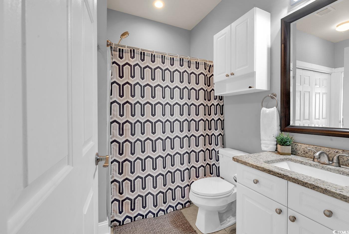 4829 Luster Leaf Circle, Unit 301 Myrtle Beach, SC 29577 - Photo 22 of 34 Bathroom featuring curtained shower, vanity, and light tile patterned floors