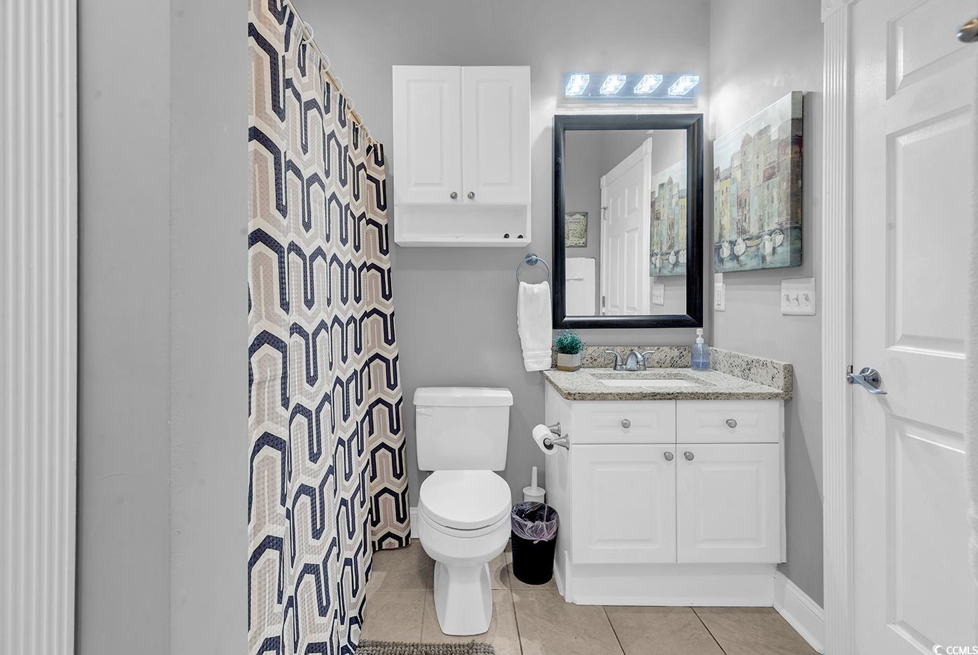 4829 Luster Leaf Circle, Unit 301 Myrtle Beach, SC 29577 - Photo 24 of 34 Full bathroom with light tile patterned floors, vanity, and a shower with curtain