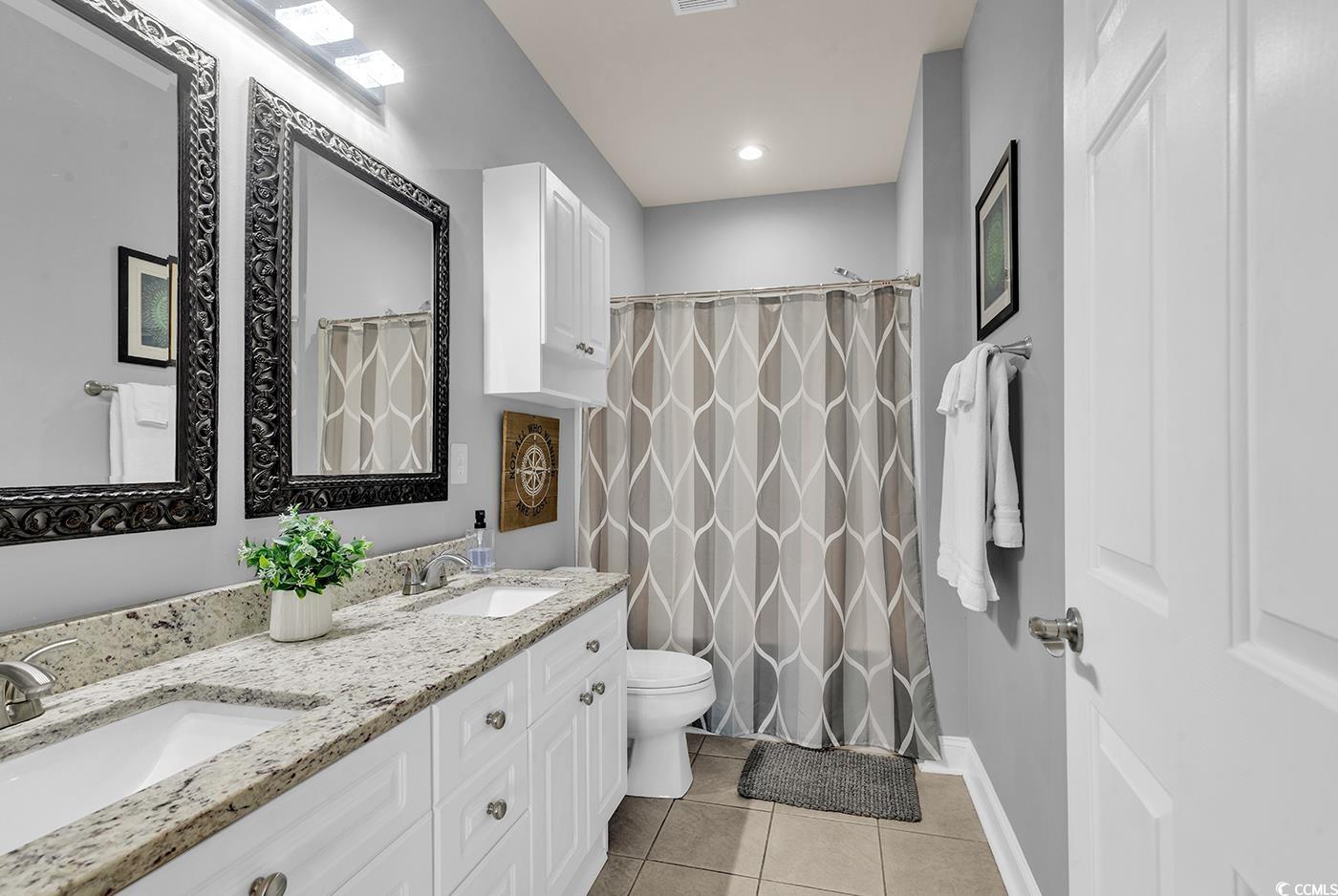 4829 Luster Leaf Circle, Unit 301 Myrtle Beach, SC 29577 - Photo 30 of 34 Full bath with light tile patterned floors, double vanity, and a shower with curtain
