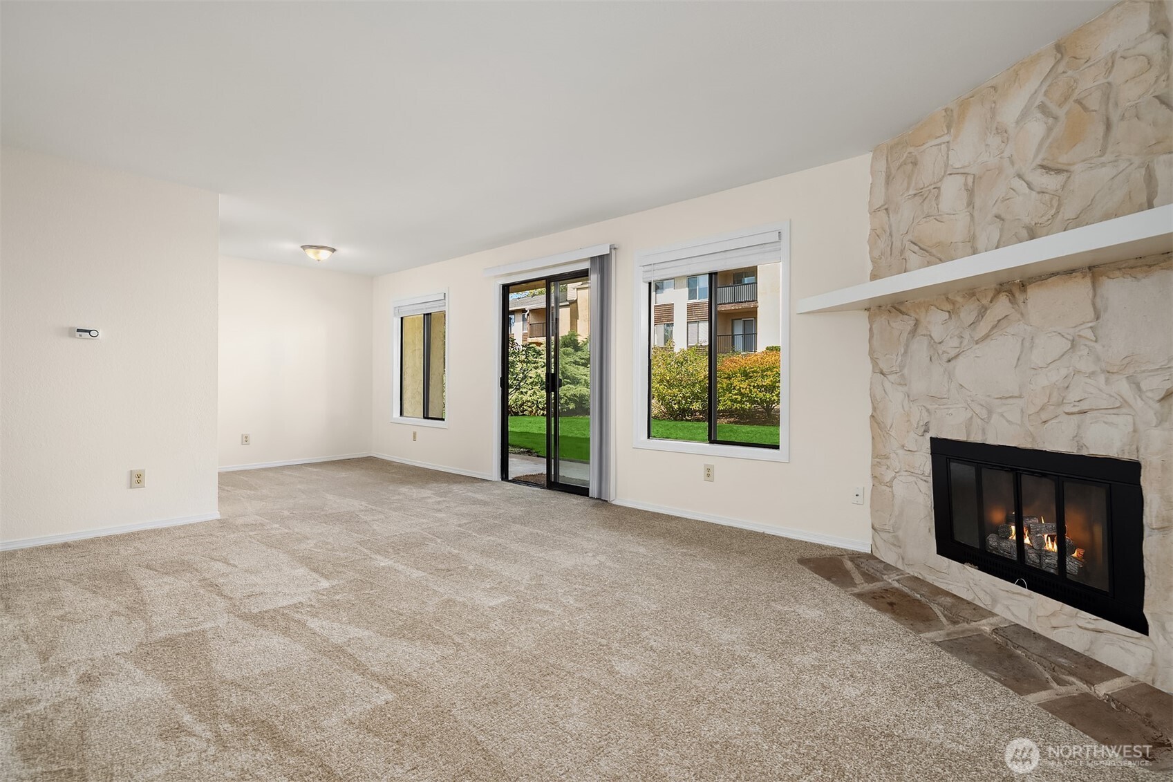 12424 Northeast 145th Street, Unit C25 Kirkland, WA 98034 - Photo 12 of 40 a view of an empty room with a fireplace and a window