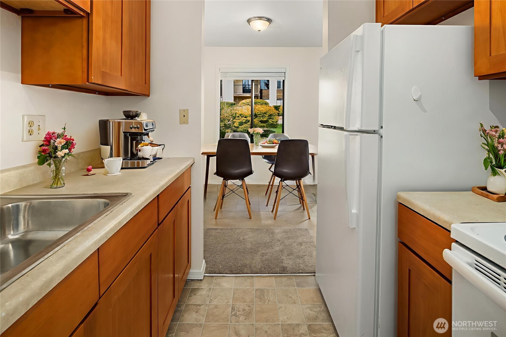 12424 Northeast 145th Street, Unit C25 Kirkland, WA 98034 - Photo 5 of 40 a kitchen with stainless steel appliances granite countertop a refrigerator sink and cabinets