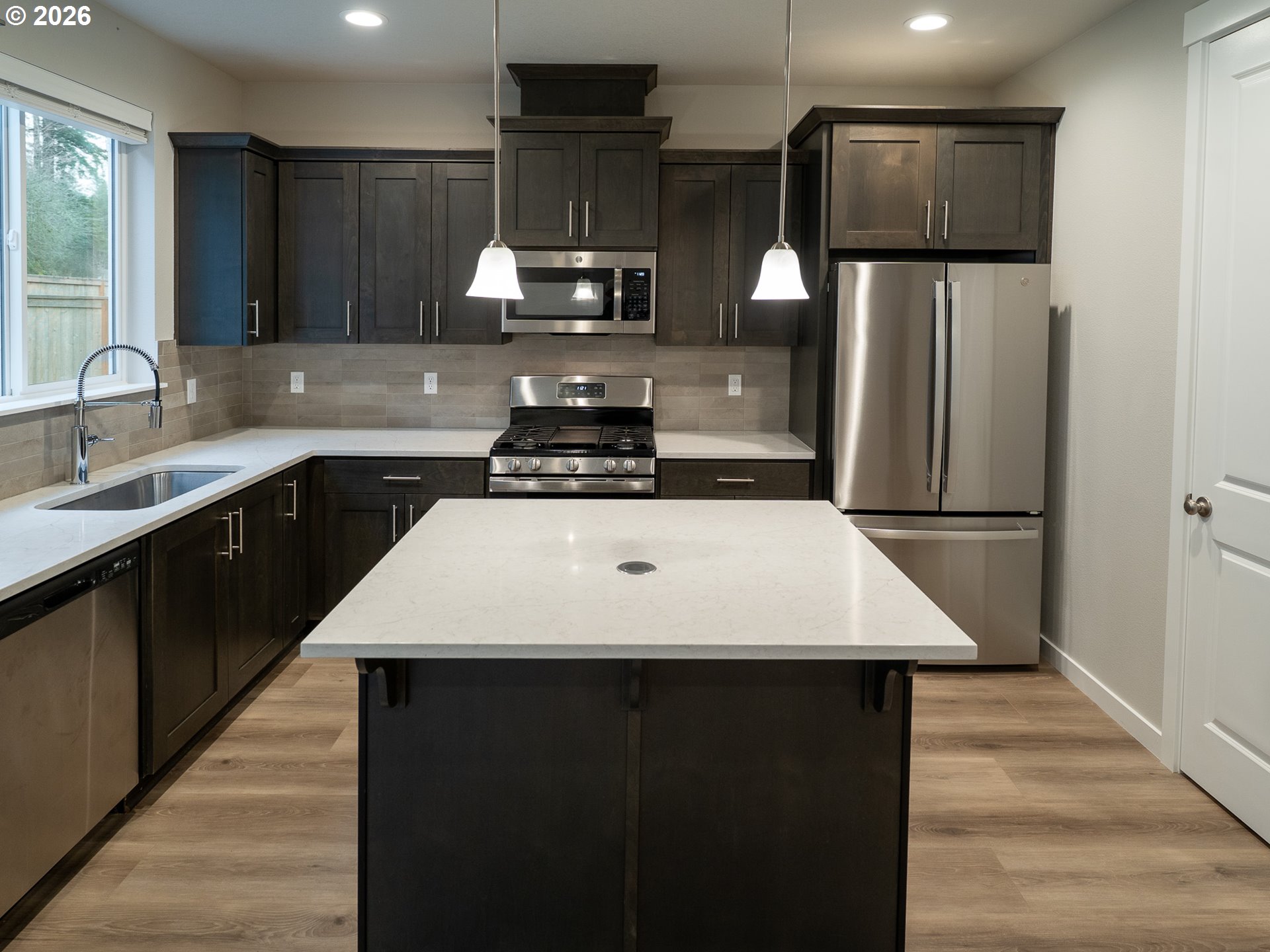 10495 Southeast Heritage Road Happy Valley, OR 97086 - Photo 11 of 46 a kitchen with a sink a refrigerator and a stove top oven