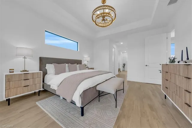 a bedroom with a bed and a chandelier