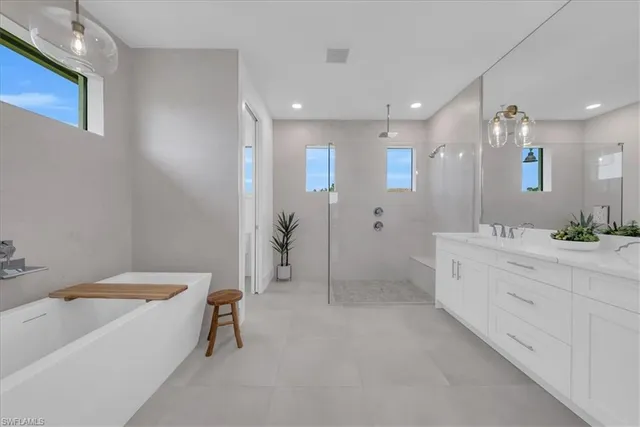a bathroom with a tub a sink and mirror