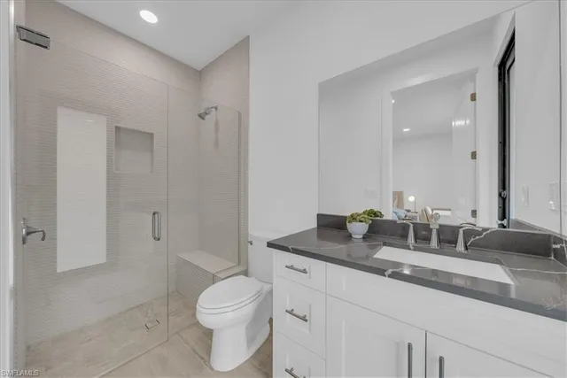 a bathroom with a granite countertop toilet a sink and a mirror