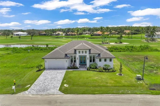 a view of a big house with a big yard and large trees