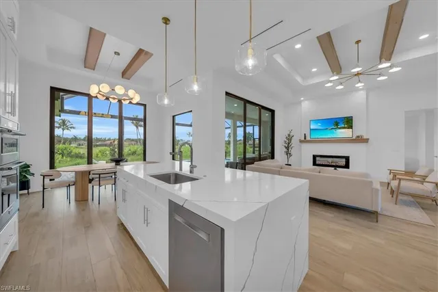 a large white kitchen with a large window and stainless steel appliances
