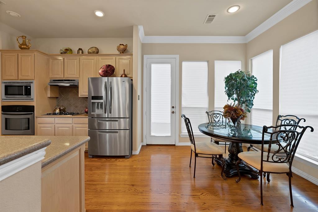 1014 Ricci Court Irving, TX 75062 - Photo 12 of 30 Kitchen with light brown cabinets, stainless steel appliances, light wood finished floors, decorative backsplash, and ornamental molding