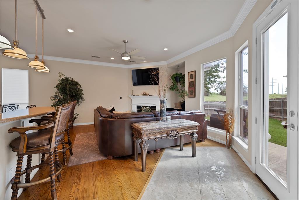 1014 Ricci Court Irving, TX 75062 - Photo 13 of 30 Living area featuring crown molding, light wood finished floors, a fireplace, ceiling fan, and recessed lighting