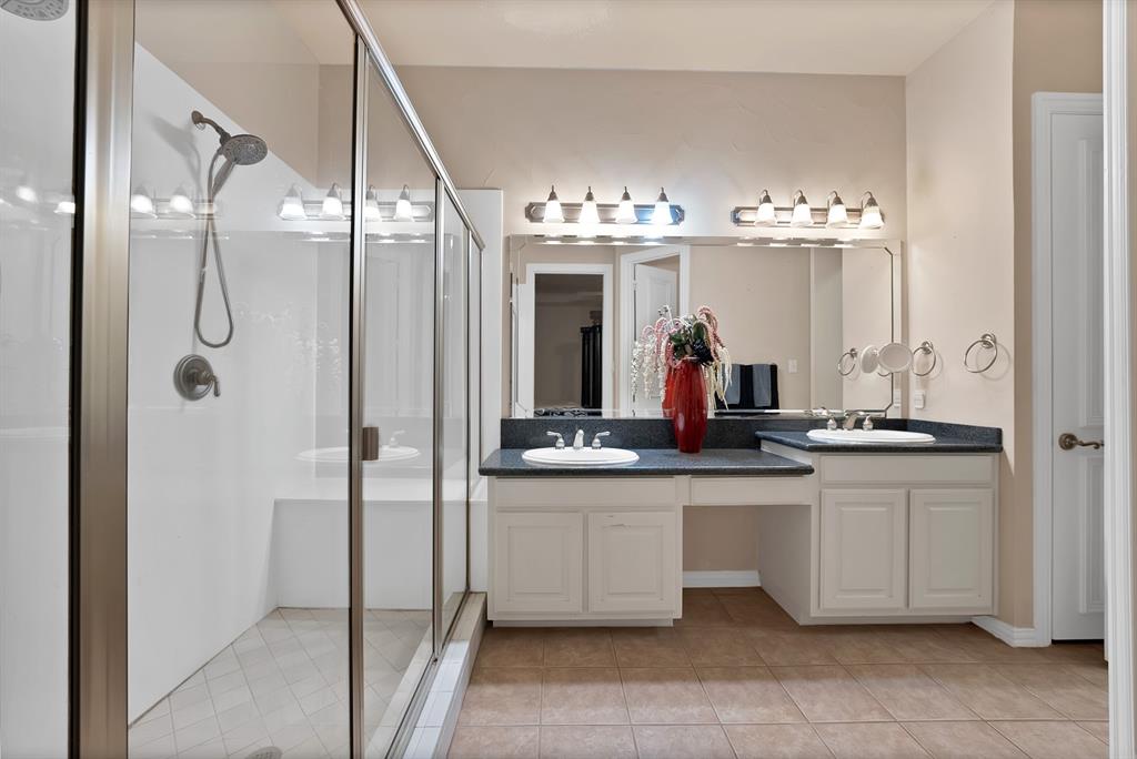 1014 Ricci Court Irving, TX 75062 - Photo 15 of 30 Full bathroom featuring a stall shower, light tile patterned floors, and double vanity