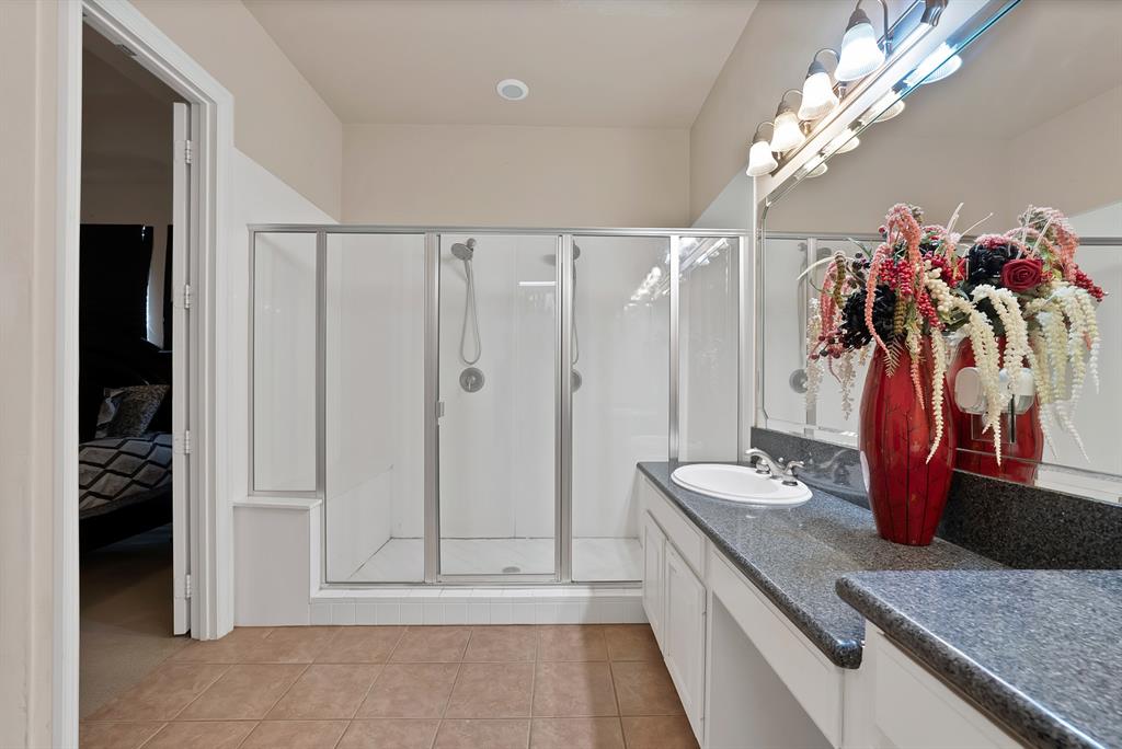 1014 Ricci Court Irving, TX 75062 - Photo 16 of 30 Bathroom featuring light tile patterned floors, vanity, a shower stall, and ensuite bath