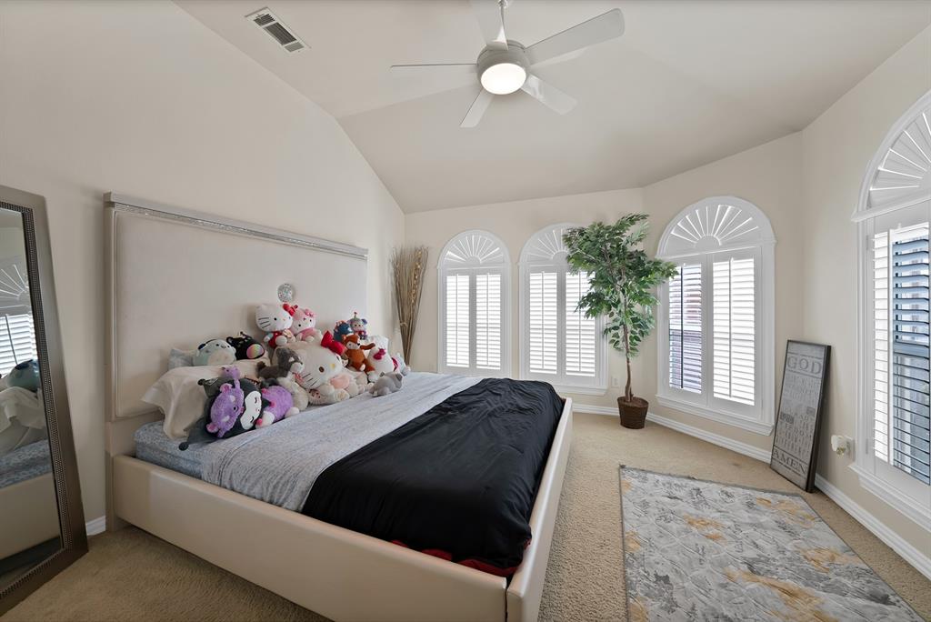 1014 Ricci Court Irving, TX 75062 - Photo 21 of 30 Bedroom featuring light colored carpet, multiple windows, lofted ceiling, and ceiling fan