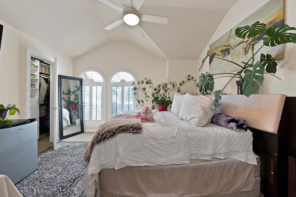 1014 Ricci Court Irving, TX 75062 - Photo 22 of 30 Carpeted bedroom with stainless steel refrigerator, vaulted ceiling, a spacious closet, and ceiling fan