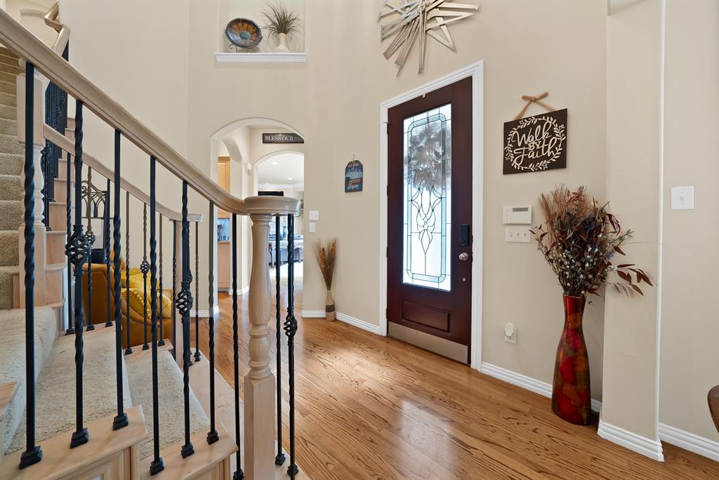 1014 Ricci Court Irving, TX 75062 - Photo 6 of 30 Foyer featuring arched walkways, light wood-style flooring, stairway, and a high ceiling