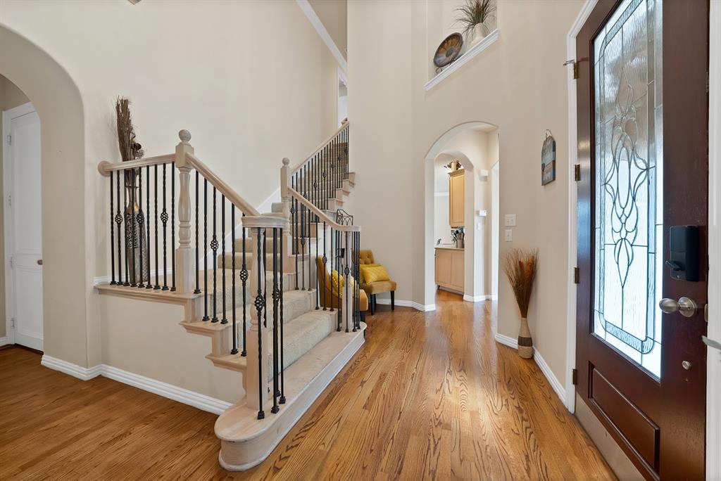 1014 Ricci Court Irving, TX 75062 - Photo 8 of 30 Foyer entrance with arched walkways, light wood-style flooring, and a towering ceiling