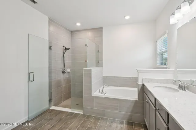 a bathroom with a granite countertop sink a mirror and a bathtub