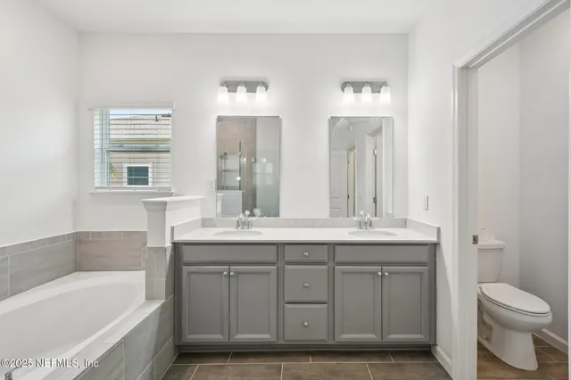 a bathroom with a granite countertop sink a toilet and bathtub