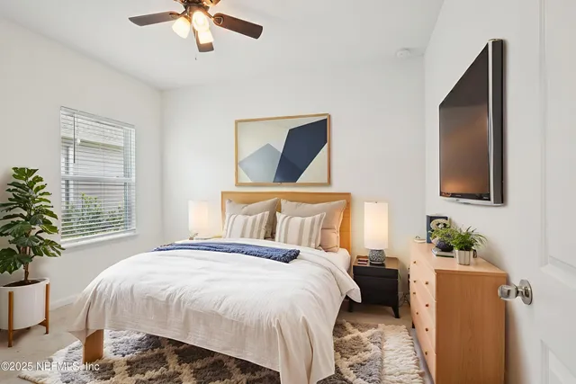 a bedroom with a bed and a potted plant