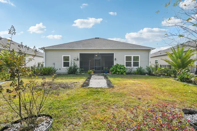 a view of a house with a yard and potted plants