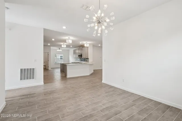 a large kitchen with kitchen island a stove a sink a center island and wooden floor