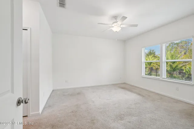 a view of an empty room with a chandelier fan
