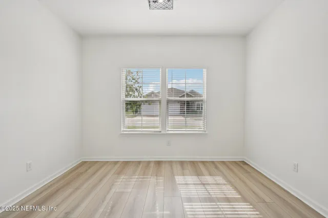 an empty room with a chandelier fan