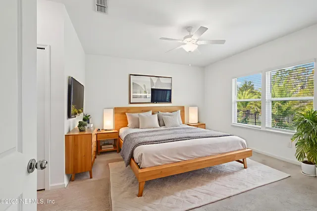 a bedroom with a large bed and a chandelier