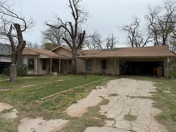a view of a white house with a large tree