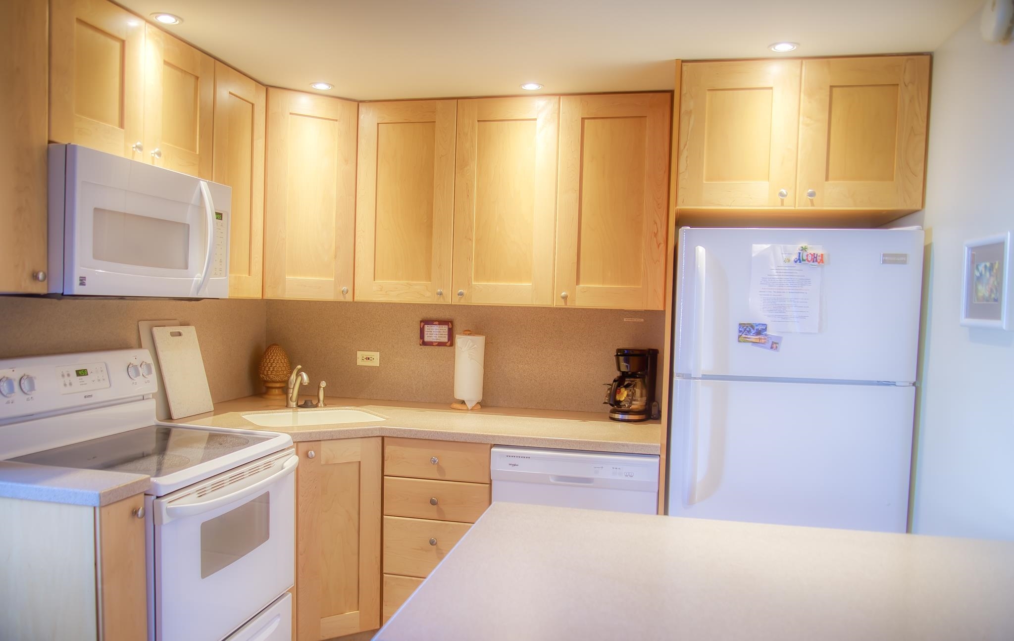 3823 Lower Honoapiilani Road, Unit 311 Lahaina, HI 96761 - Photo 13 of 20 a kitchen with a sink a refrigerator and cabinets