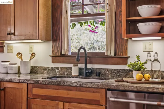 a kitchen with stainless steel appliances granite countertop a refrigerator and wooden cabinets