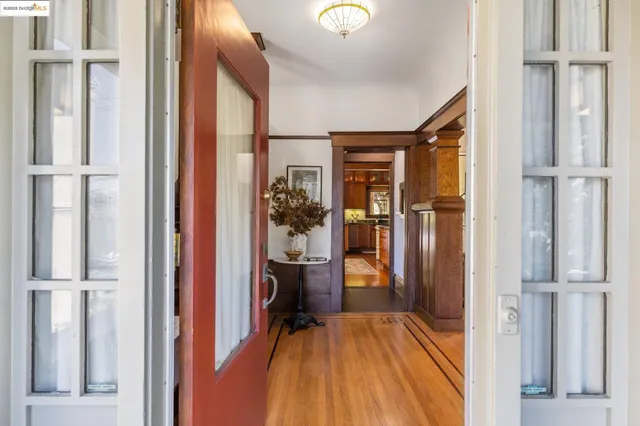 a view of a hallway with wooden floor and a living room