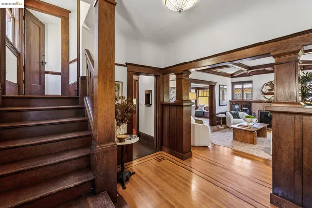 a view of a living room with a fireplace and wooden floor