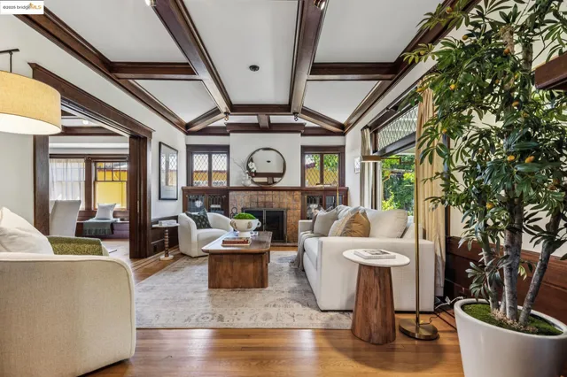 a living room with furniture a fireplace a large window and a potted plant