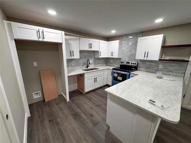 a kitchen with a sink a stove a refrigerator and a oven