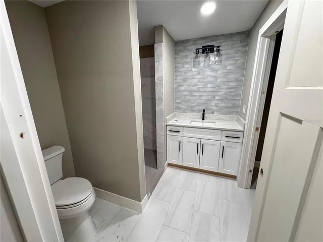a bathroom with a sink toilet and mirror
