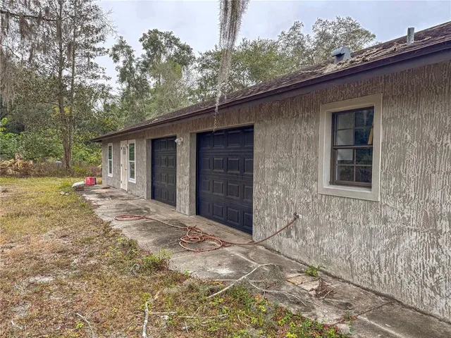 a backyard of a house with table and chairs